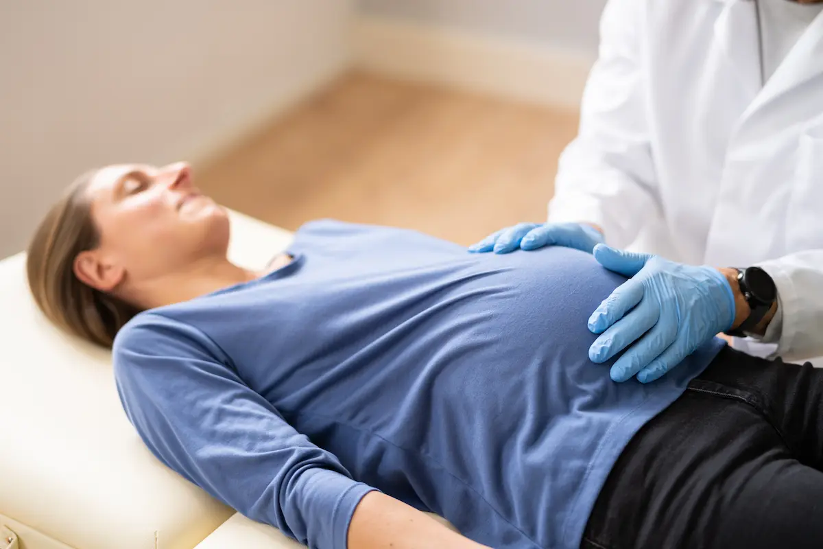 Doctor checking pregnant woman’s belly